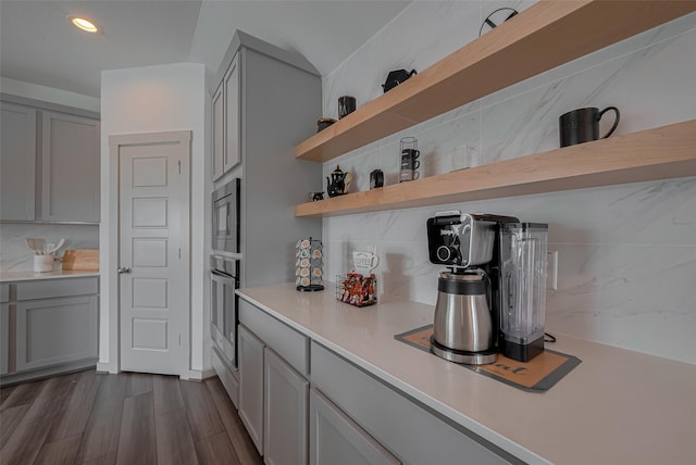 bar with recessed lighting, appliances with stainless steel finishes, decorative backsplash, and dark wood-type flooring