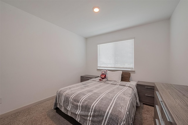 bedroom with baseboards and dark colored carpet