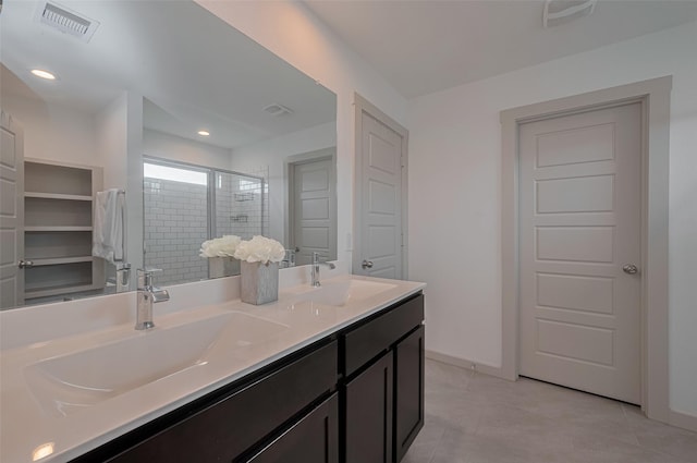 bathroom featuring double vanity, visible vents, a sink, and a stall shower