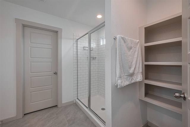 full bath featuring baseboards, tile patterned flooring, and a stall shower