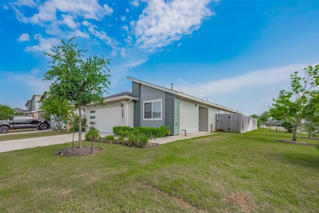 view of side of home with a lawn, fence, driveway, and a garage