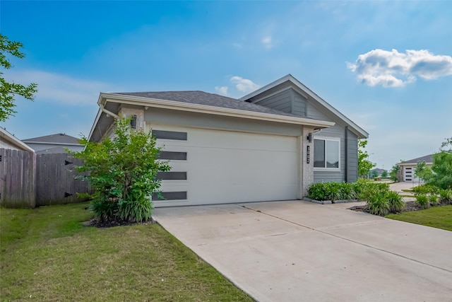 view of property exterior featuring fence, a yard, driveway, and a garage