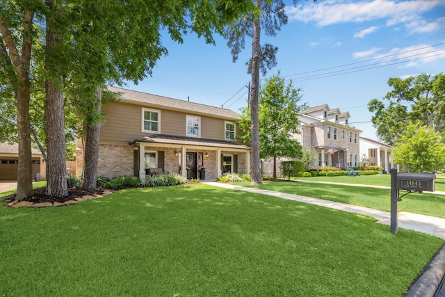 view of front of property featuring covered porch, brick siding, and a front yard