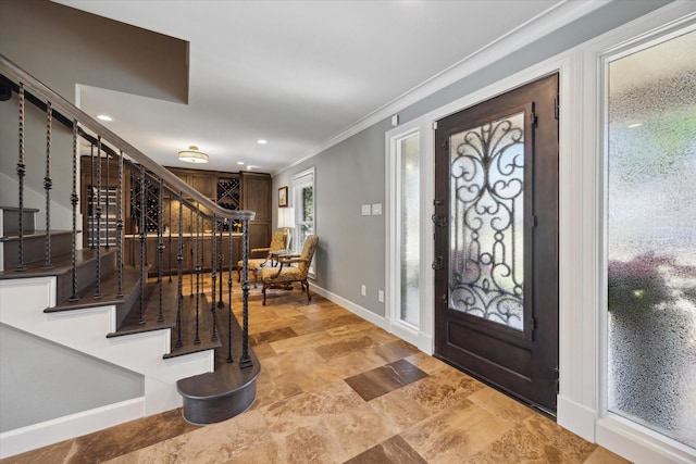 entryway with stairway, baseboards, ornamental molding, and recessed lighting