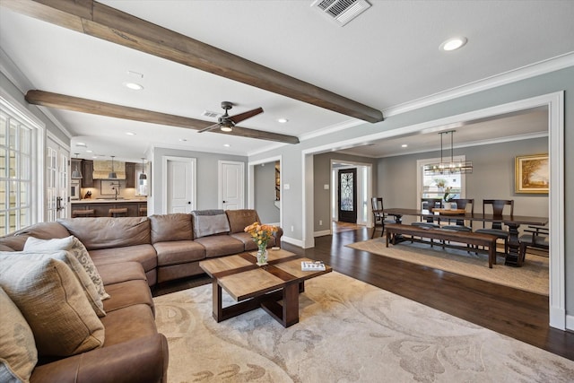 living room featuring beam ceiling, dark wood finished floors, recessed lighting, visible vents, and ornamental molding