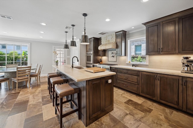 kitchen with ornamental molding, custom exhaust hood, recessed lighting, a sink, and backsplash