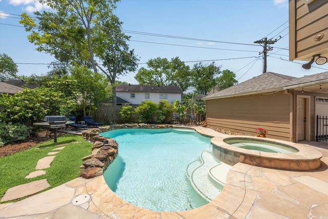 view of pool with a pool with connected hot tub and a fenced backyard