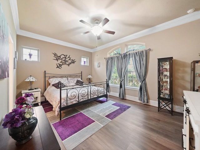 bedroom with crown molding, baseboards, ceiling fan, and wood finished floors