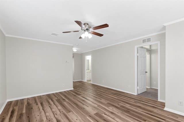 empty room featuring ceiling fan, baseboards, visible vents, and wood finished floors