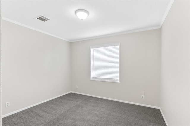spare room featuring baseboards, visible vents, ornamental molding, and dark colored carpet