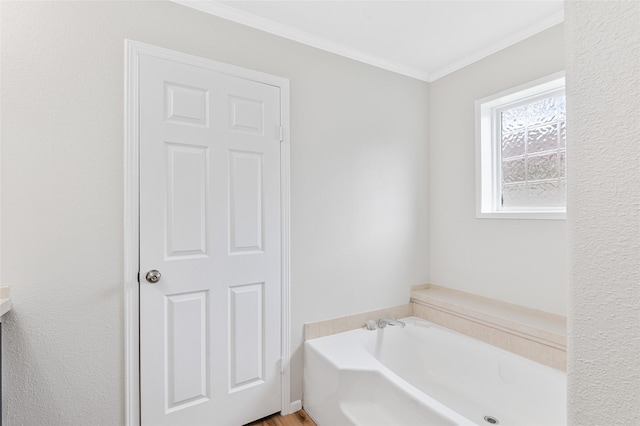bathroom with ornamental molding and a garden tub