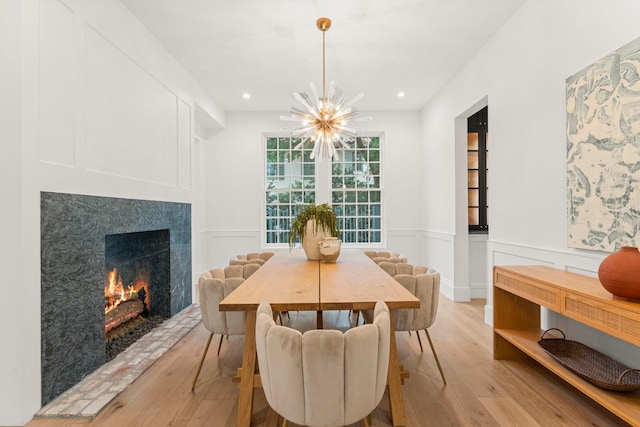 2530 Stanmore Dr, Houston, TX 77019 - dining area with light wood-style floors, a high end fireplace, a chandelier, wainscoting, and recessed lighting