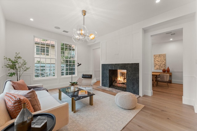 2530 Stanmore Dr, Houston, TX 77019 - living area featuring light wood finished floors, a premium fireplace, a chandelier, and recessed lighting