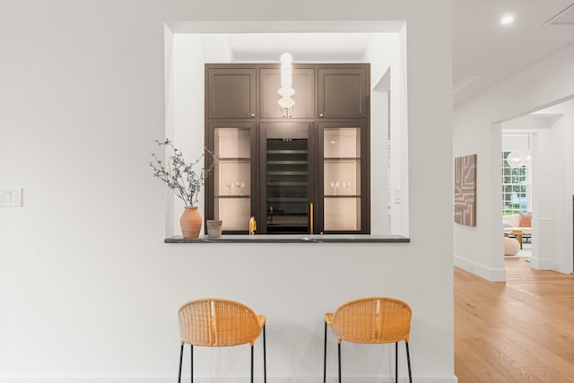 2530 Stanmore Dr, Houston, TX 77019 - kitchen with light wood-style floors, a kitchen breakfast bar, baseboards, and recessed lighting