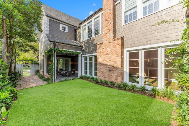 2530 Stanmore Dr, Houston, TX 77019 - rear view of house with a lawn, a gate, brick siding, a chimney, and a patio