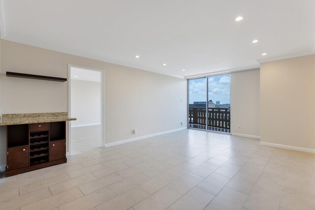 unfurnished living room with crown molding, baseboards, and recessed lighting