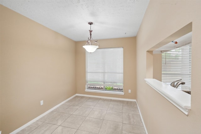 empty room featuring a healthy amount of sunlight, baseboards, and light tile patterned floors