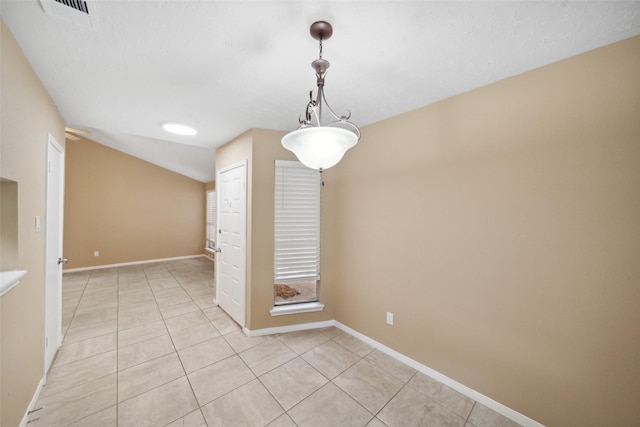 empty room featuring baseboards, light tile patterned floors, visible vents, and vaulted ceiling