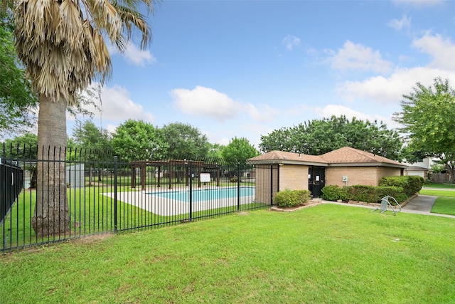 community pool with fence and a yard