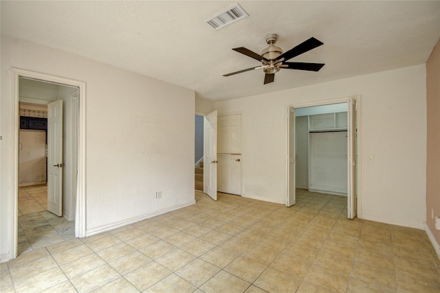 unfurnished bedroom with ceiling fan, visible vents, light tile patterned floors, baseboards, and a closet