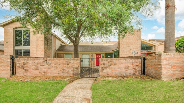 view of front of house featuring brick siding, a fenced front yard, a gate, and a front yard