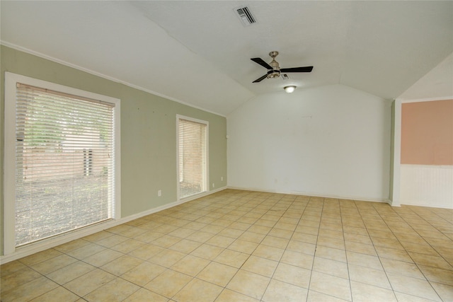 spare room featuring ceiling fan, visible vents, crown molding, vaulted ceiling, and light tile patterned flooring