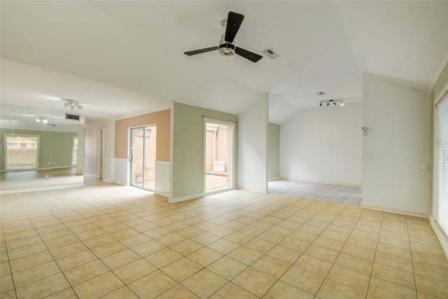 spare room featuring visible vents, light tile patterned flooring, a healthy amount of sunlight, ceiling fan, and vaulted ceiling