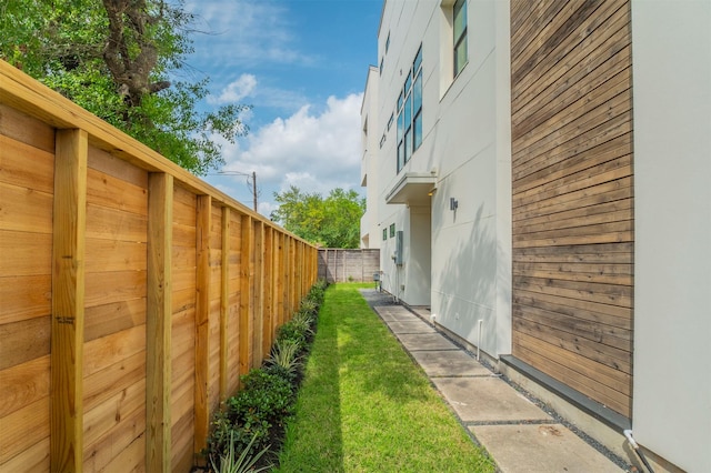 view of side of property with fence and a yard