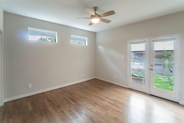 empty room with a ceiling fan, baseboards, french doors, and light wood finished floors