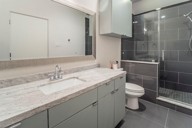 bathroom featuring vanity, tile patterned flooring, toilet, and a shower stall