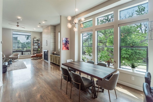 dining room featuring ceiling fan, visible vents, wood finished floors, and a wealth of natural light