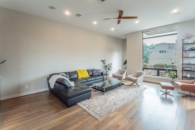living area with visible vents, wood finished floors, recessed lighting, expansive windows, and a ceiling fan