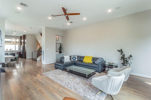 living room with baseboards, visible vents, wood finished floors, and stairway