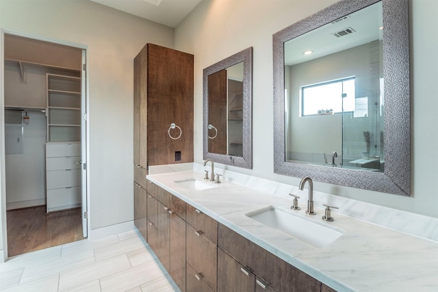 bathroom with visible vents, a sink, a spacious closet, and a stall shower