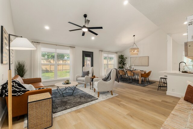 living room with recessed lighting, ceiling fan, lofted ceiling, and light wood-type flooring