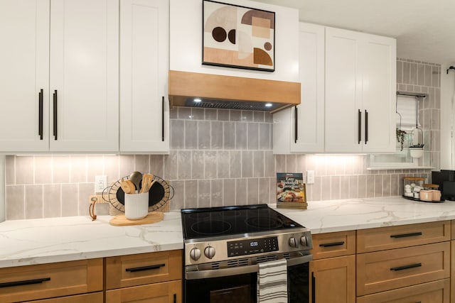 kitchen featuring light stone counters, tasteful backsplash, white cabinetry, and stainless steel range with electric cooktop