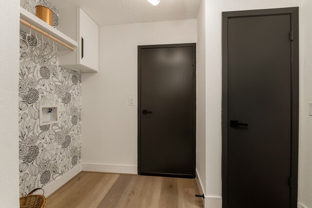 interior space featuring baseboards and light wood finished floors