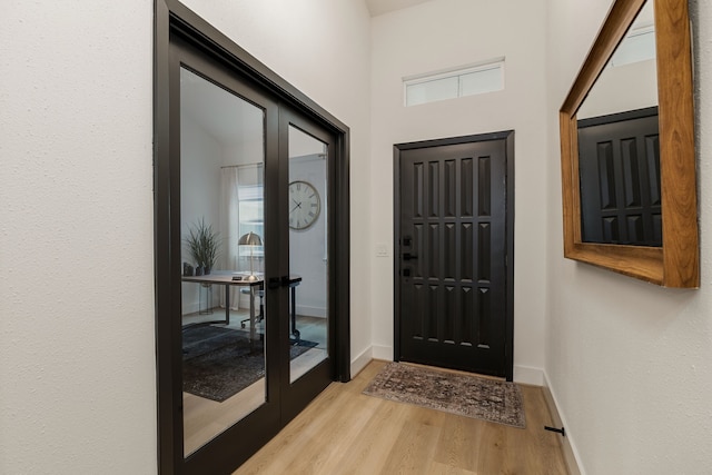 doorway featuring baseboards and wood finished floors