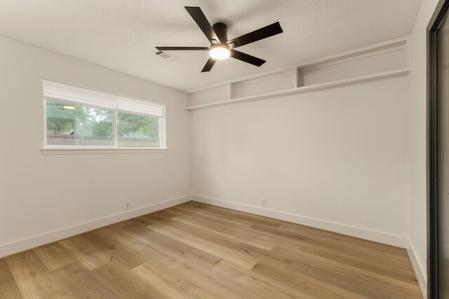 spare room with a ceiling fan, baseboards, visible vents, and light wood finished floors