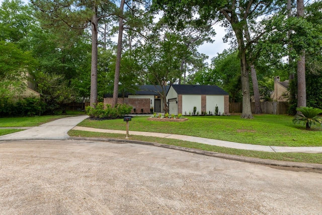 view of front of home with a front lawn, fence, and concrete driveway