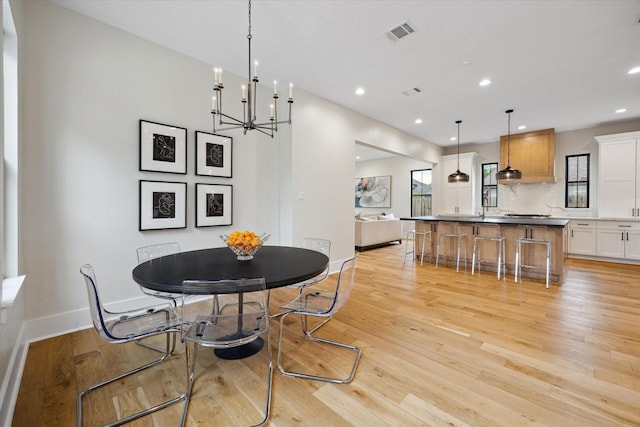 dining space with baseboards, visible vents, a wealth of natural light, and light wood-style floors