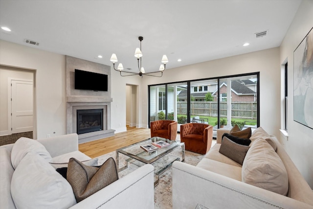 living room with recessed lighting, visible vents, a chandelier, and a fireplace