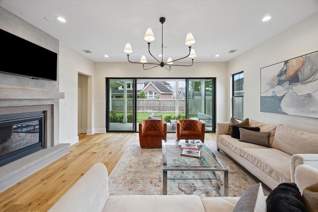 living room with visible vents, recessed lighting, wood finished floors, and a notable chandelier