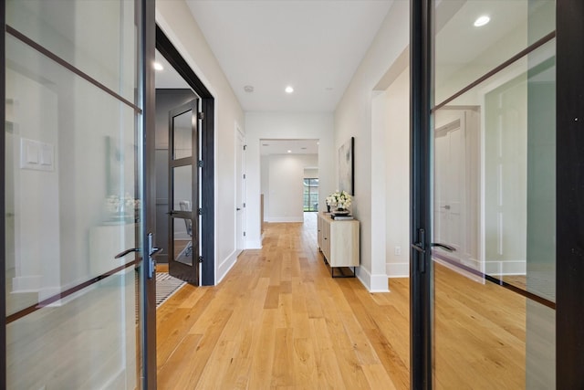 hallway featuring french doors, recessed lighting, baseboards, and light wood-type flooring