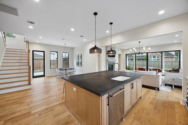 kitchen with dark countertops, visible vents, a sink, and light wood-type flooring