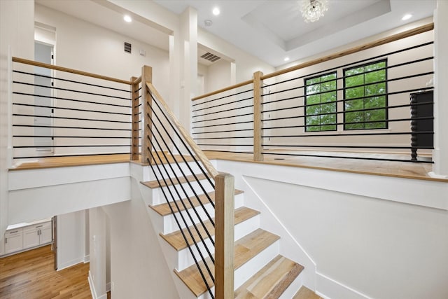 stairs with baseboards, recessed lighting, wood finished floors, and visible vents