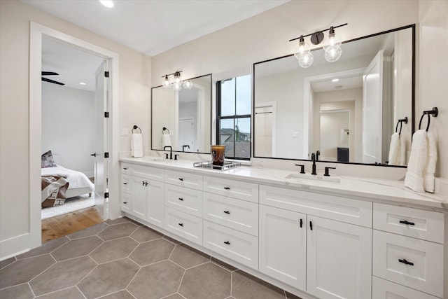 bathroom with double vanity, a sink, ensuite bathroom, and recessed lighting
