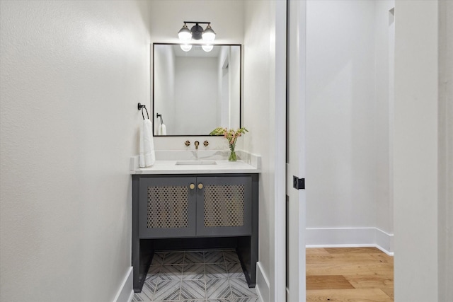 bathroom with vanity, baseboards, and wood finished floors