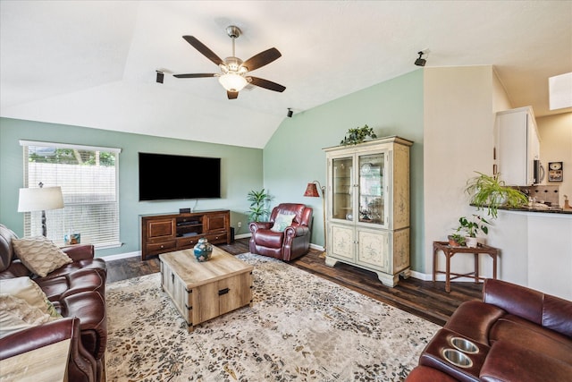 living area with baseboards, ceiling fan, vaulted ceiling, and wood finished floors