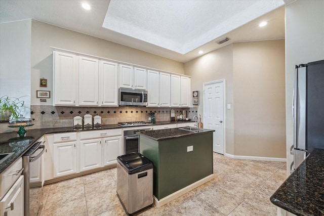 kitchen featuring visible vents, white cabinetry, a sink, backsplash, and stainless steel appliances